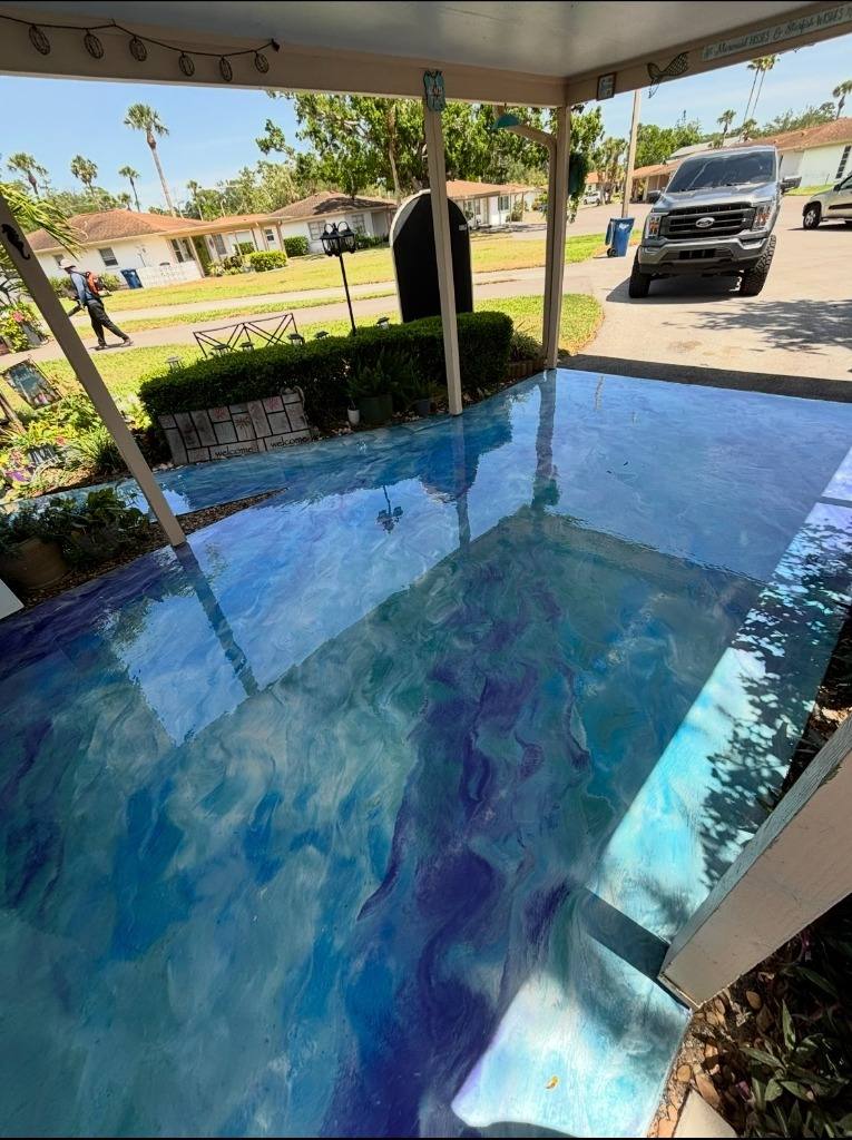 Blue and purple metallic epoxy floor on a covered carport, open to the street