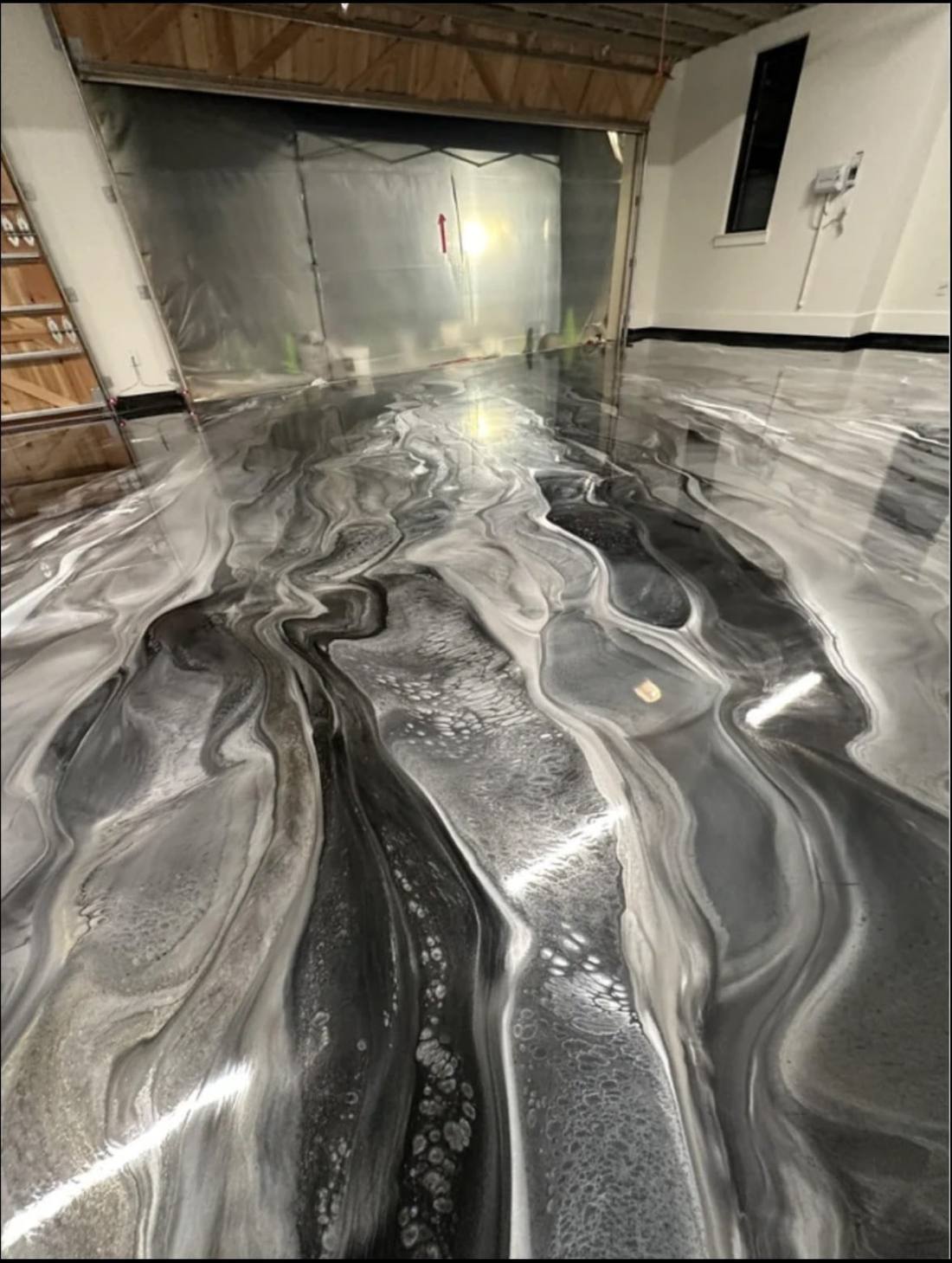 Black and silver metallic floor in a garage, with a swirled marble pattern